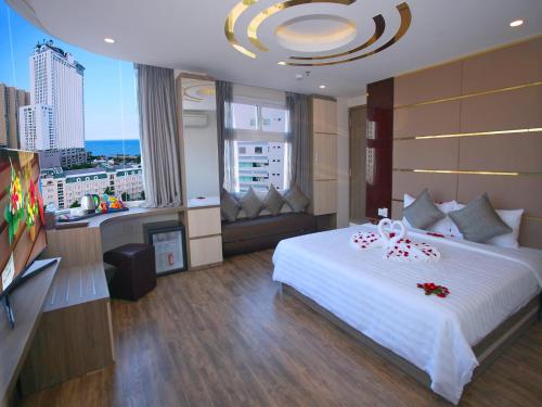 a bedroom with a large white bed and a large window at New Sun Hotel in Nha Trang