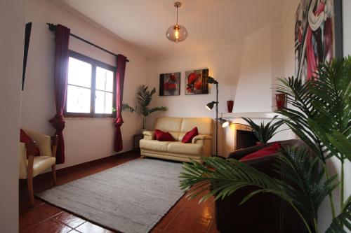 Una sala de estar con un sofá y una ventana. en Casa Papoila T1 com terraço, en Vila Nova de Milfontes