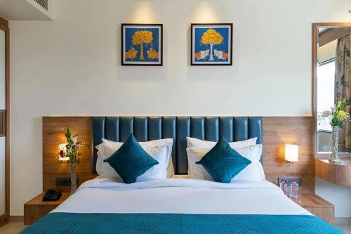 a bedroom with a bed with blue and white pillows at Redolence Aravali Tree in Udaipur