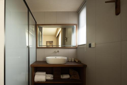 ブ源県にあるWuyuan Jingmuo Liangxi Guest Houseの洗面台と鏡のあるバスルーム
