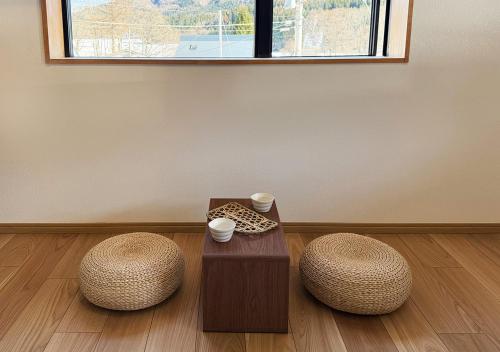 a room with two stools and a table and a window at 白馬の黒馬　DarkHorse @Hakuba in Hakuba