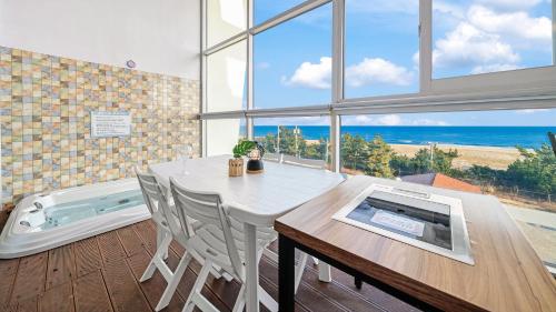 a dining room with a table and a view of the ocean at Yangyang Oceanvibe in Yangyang