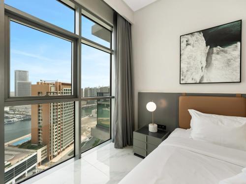 a bedroom with a bed and a large window at Downtown Panoramic View in Dubai