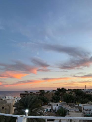 a sunset over a city with palm trees and buildings at Havana House in Dahab