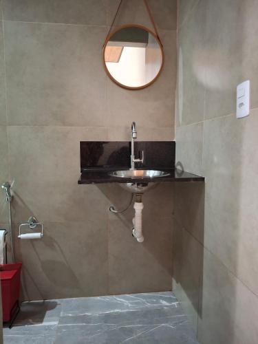 a bathroom with a sink and a mirror at Chalé do galo in São Domingos