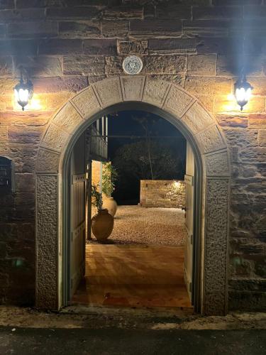 an archway in a stone wall with a bed at Pietra Rossa in Chios