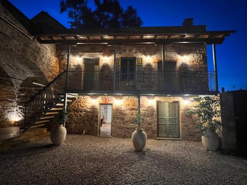 a stone house with lights on the side of it at Pietra Rossa in Chios