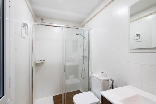 a bathroom with a shower and a toilet and a sink at Casa Menvil in Sant Jordi de Cercs