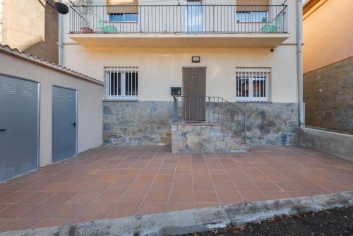 a patio in front of a house with a blue door at Casa Menvil in Sant Jordi de Cercs
