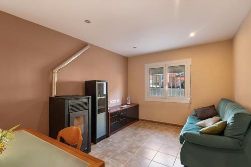 a living room with a couch and a refrigerator at Casa Menvil in Sant Jordi de Cercs