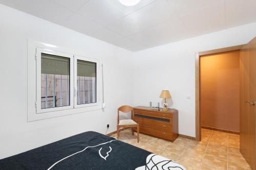 a bedroom with a bed and a desk and window at Casa Menvil in Sant Jordi de Cercs