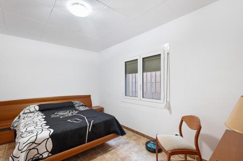 a bedroom with a bed and a window at Casa Menvil in Sant Jordi de Cercs