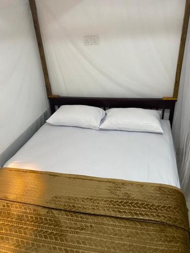 a bed with two pillows on top of it at Aromin Ayurvedic Palace in Weligama