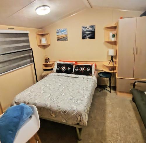 a small bedroom with a bed and a refrigerator at Seascape Costal Venture at Winchelsea Beach in Winchelsea