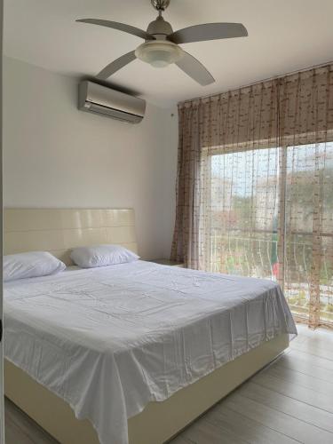 a bedroom with a bed with a ceiling fan and a window at Luxury sea Cadaques Caribe in Bayahibe