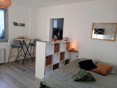 une chambre avec un lit, une table et un miroir dans l'établissement L'Urban centre ville linge café thé inclus, à Vannes