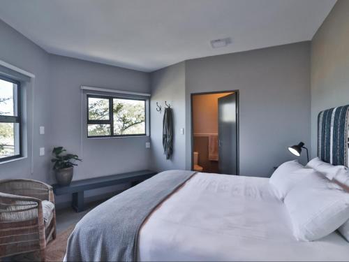 a bedroom with a large white bed and a window at Budapest Boutique Hotel in Edgemead