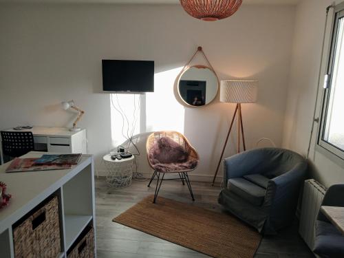 un salon avec une chaise et un miroir dans l'établissement L'Urban centre ville linge café thé inclus, à Vannes