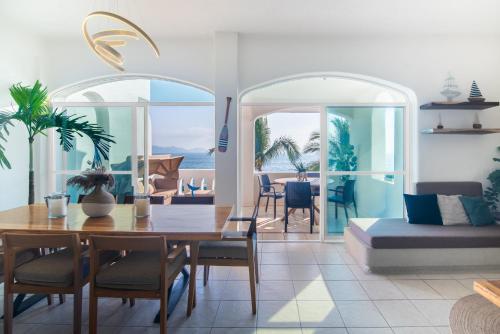 a dining room with a table and chairs and a living room at Vista al Mar, Terraza y Albercas in Manzanillo