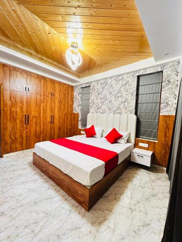 a bedroom with a large bed with red pillows at Dreamville Stays Shimla - Luxury Homestay and B&B in Shimla