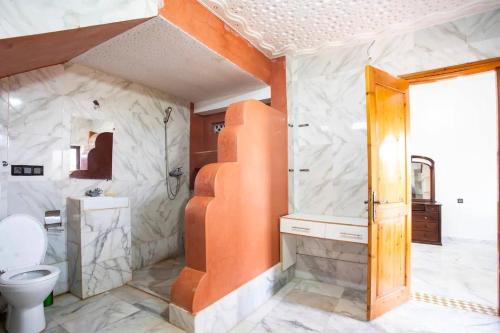 an orange and white bathroom with a toilet and a sink at Luxury Villa at the foot of the Grand Atlas in Tillouna