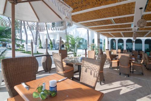 a restaurant with tables and chairs and an umbrella at Vista al Mar, Terraza y Albercas in Manzanillo