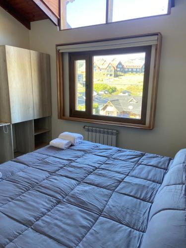 a bedroom with a large bed with a large window at De los Tres in El Chalten
