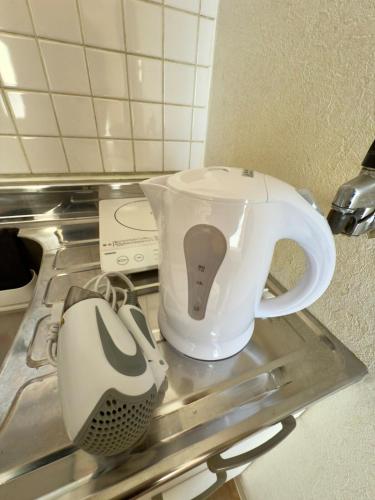 a white tea pot sitting on top of a drying machine at 2-6大通駅まで地下鉄で4駅の場所で美室のリフォーム済みアパートメント in Sapporo