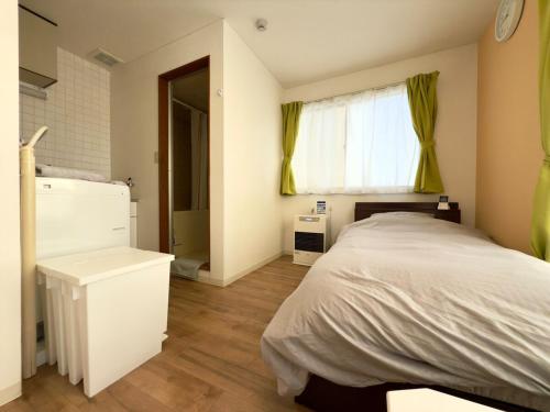 a bedroom with a large bed and a window at 2-6大通駅まで地下鉄で4駅の場所で美室のリフォーム済みアパートメント in Sapporo