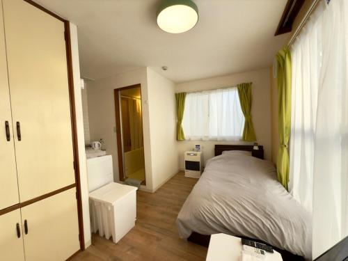a small bedroom with a bed and a window at 2-6大通駅まで地下鉄で4駅の場所で美室のリフォーム済みアパートメント in Sapporo