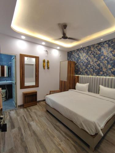 a bedroom with a large bed and a mirror at Hotel Strawberry in Chandīgarh