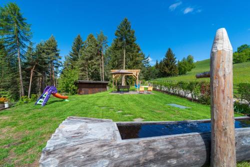 a large yard with a playground with a slide at Haus Oberzöhr in Nova Ponente