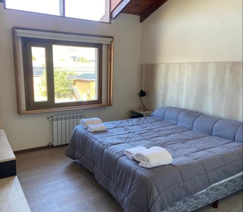 a bedroom with a large bed with towels on it at De los Tres in El Chalten