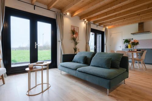 a living room with a green couch and a table at Vakantiehuis Blok 25 in Zierikzee