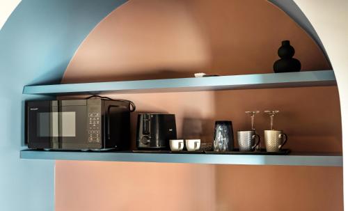 a black microwave on a shelf in a room at Arches Apartments in Athens