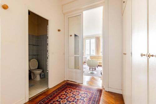 un couloir avec des toilettes et une porte avec un tapis dans l'établissement appartement pres de la tour eiffel, à Paris