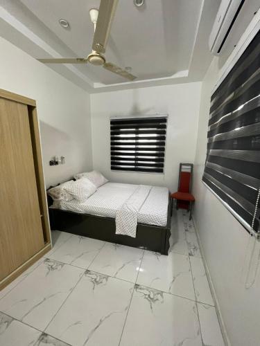 a bedroom with a bed and a window and a chair at RESIDENCE ORELIO Agoè in Agbéli