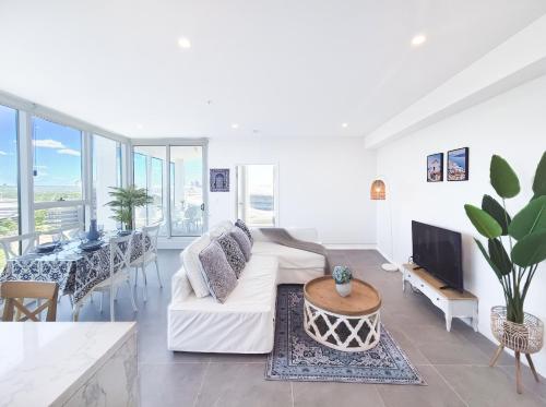 a living room with a couch and a table at Olympic Park Escape 2BR w Gym, Pool & Free Parking in Sydney
