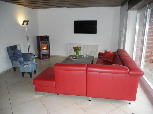 a living room with a red couch and a table at Fehmarn Ostseeferien Ferienhaus Keinemann 113 1 in Püttsee