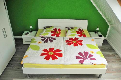 a bedroom with a bed with a green wall at Fehmarn Ostseeferien Ferienhaus Keinemann 113 1 in Püttsee
