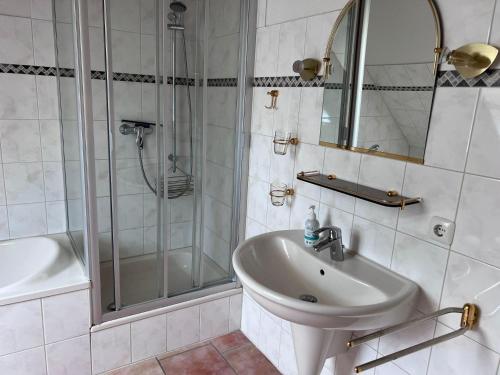 a white bathroom with a sink and a shower at FeWo Heinz in Fehmarn