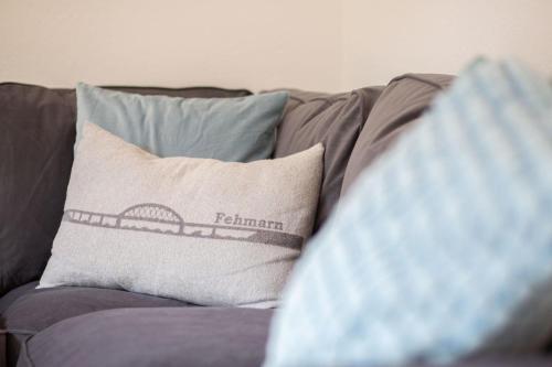 a pillow on a couch with a picture of a bridge at Fehmarn Ostseefreien Rosengarten 199 2 in Fehmarn