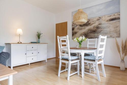 a dining room with a table and chairs at Fehmarn Ostseefreien Rosengarten 199 2 in Fehmarn