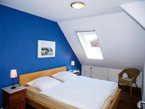 a bedroom with a bed with a blue wall at Ferienwohnung Küthe in Fehmarn