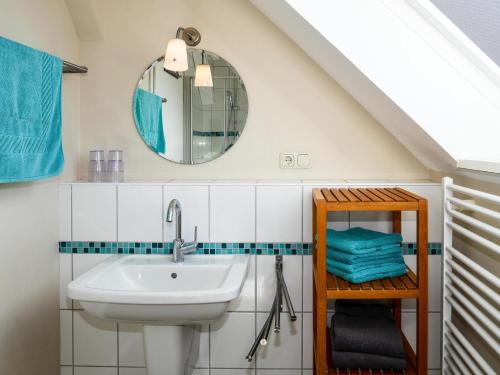 a bathroom with a sink and a mirror at Ferienwohnung Küthe in Fehmarn