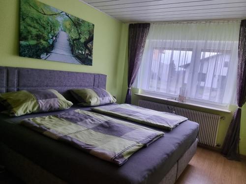 un letto in una camera da letto con un dipinto sul muro di Ferienwohnung Ziegler a Steinau an der Straße