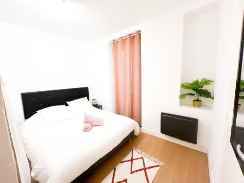 a bedroom with a white bed and a window at Hyper center - 10'St Nazaire in Trignac