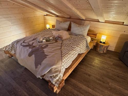 a bedroom with a large bed in a cabin at Harz - Blockhaus, 4 und 5 Sterne Blockhäuser, Sauna und Kamin in Hahnenklee-Bockswiese