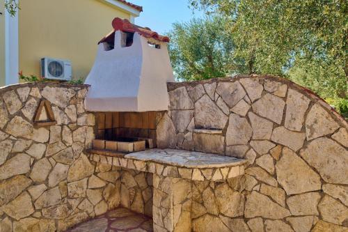 a stone outdoor kitchen with a stone wall at Villa Ariadne Periyali in Katastárion
