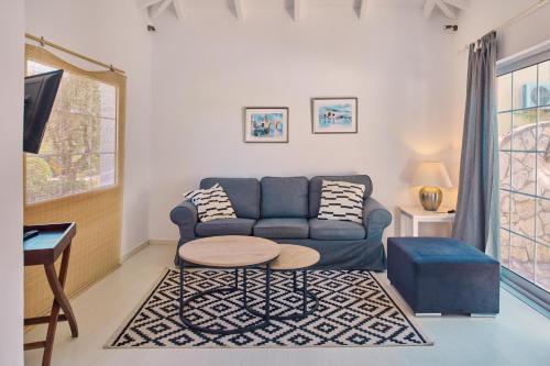 a living room with a blue couch and a table at Villa Ariadne Periyali in Katastárion